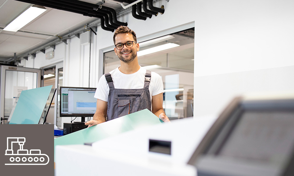 Mitarbeiter in moderner Produktionsumgebung mit Glas- oder Kunststoffplatten in der Hand – hochwertige Inhouse-Fertigung für maßgeschneiderte Lösungen in der Objektausstattung durch WESPRO Hospitality.